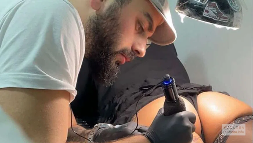 art-room-tattoo мастер делает тату на женских ягодицах