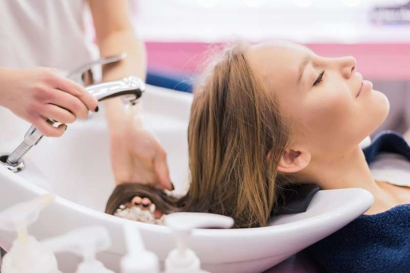 barber girl combing her hair in beauty saloon
