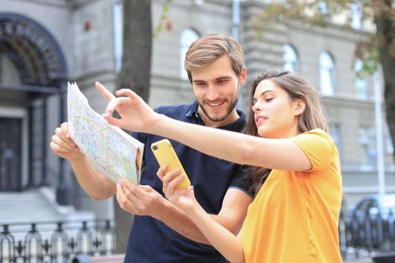 beautiful-young-couple-holding-map-smiling-w.max-800x600