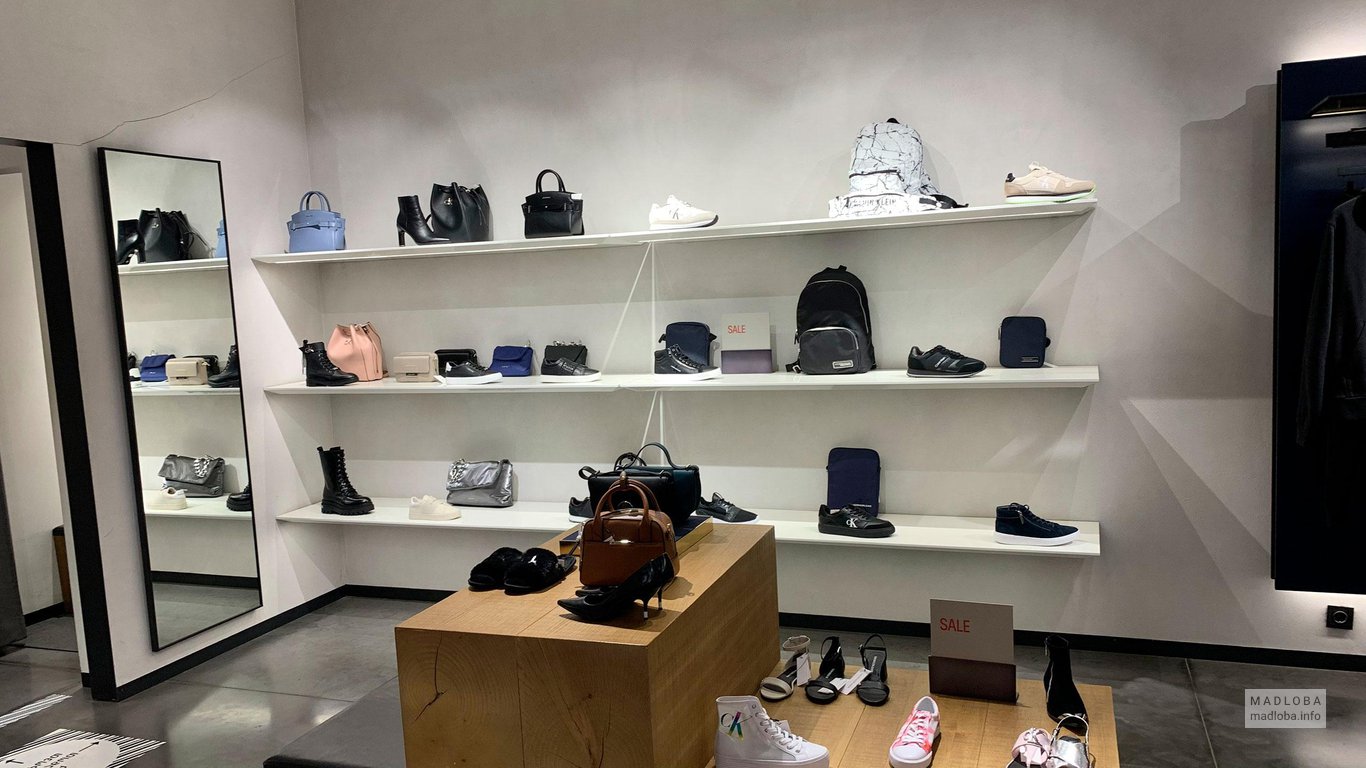 Полки с обувью и сумками в магазине Кельвин Кляйн Джинс