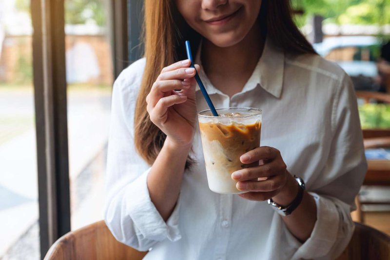 The girl is enjoying a cold coffee