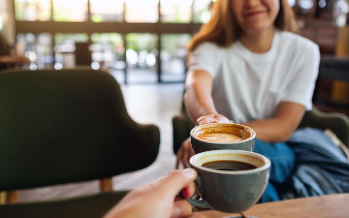 Женщина и мужчина пьют кофе в кофейне