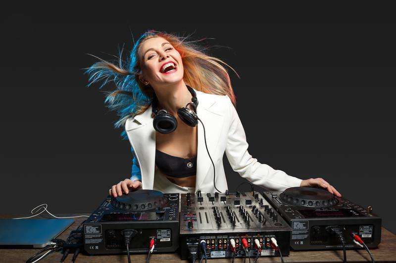 A female DJ at the console at a party