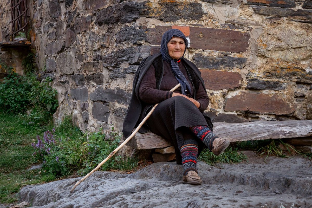 elderly-woman-sits-in-front-of-the-Svan-tower