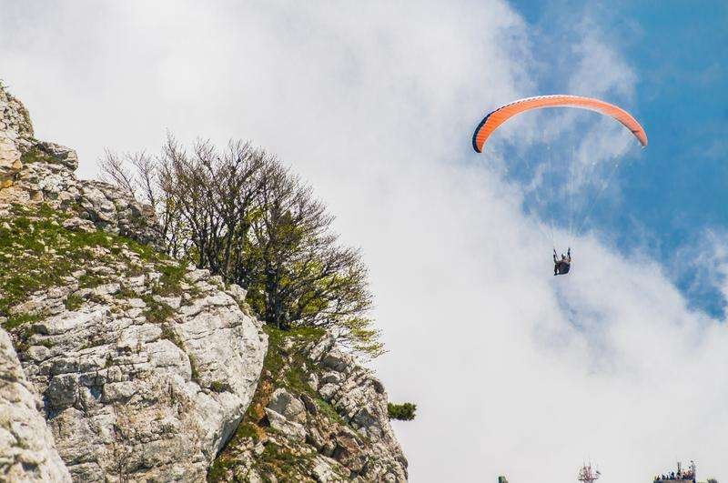 A man paragliding in the mountains