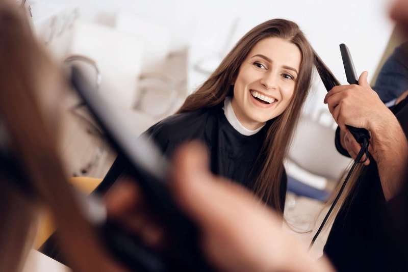female-hairdresser-using-hair-iron-straighte.max-800x600