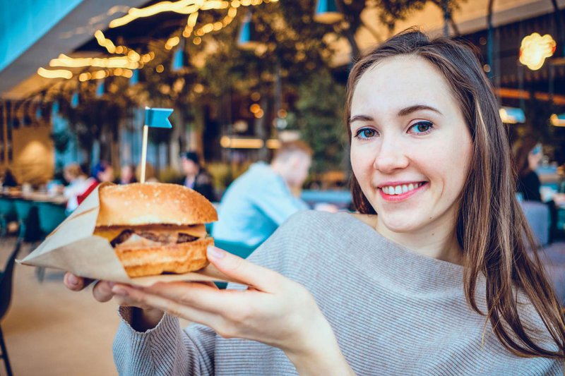 Girl with a burger in a burger joint