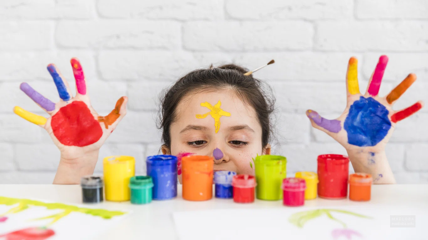 Ребенок с разноцветными красками в Kids