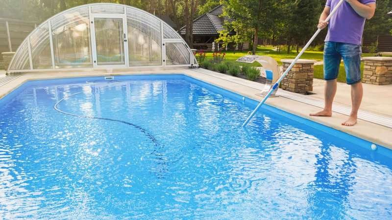 man-cleaning-swimming-pool-with-vacuum-tube-.max-800x600