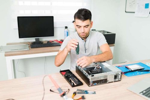 A technician at a service center disassembles a system unit