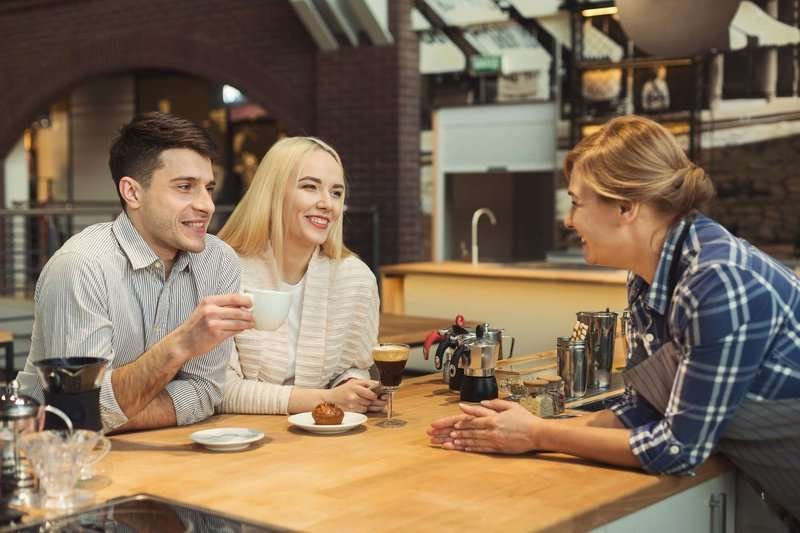 middle-aged-barista-chatting-with-guests-at-.max-800x600