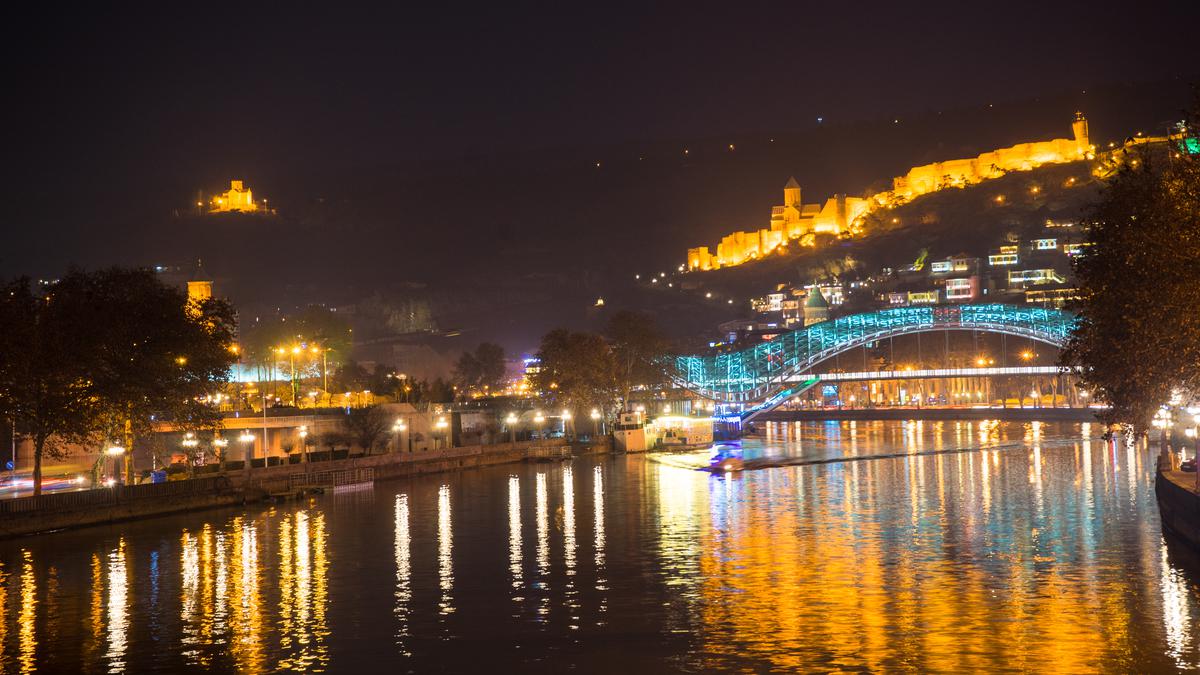Ночная подсветка моста и реки в Тбилиси