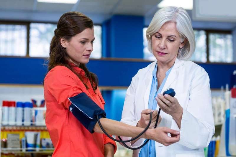 a pharmacist checks a customer's blood pressure