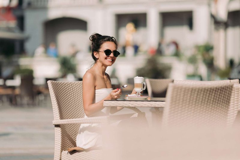 Девушка в солнцезащитных очках снаружи кафе
