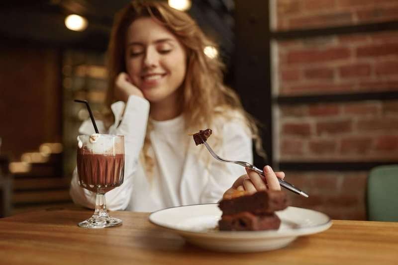 A girl eats dessert in a pastry shop