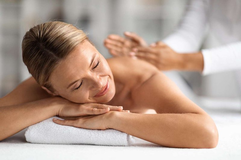 A satisfied and relaxed woman enjoys a massage