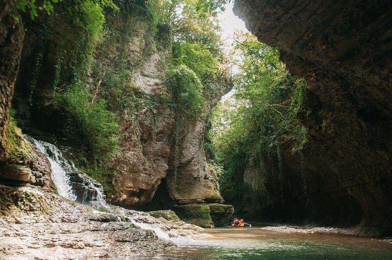 People in a boat on a river in the Martvili Gorge