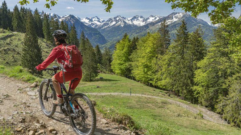 Велосипедистка в ярком костюме с видом на Кавказские горы