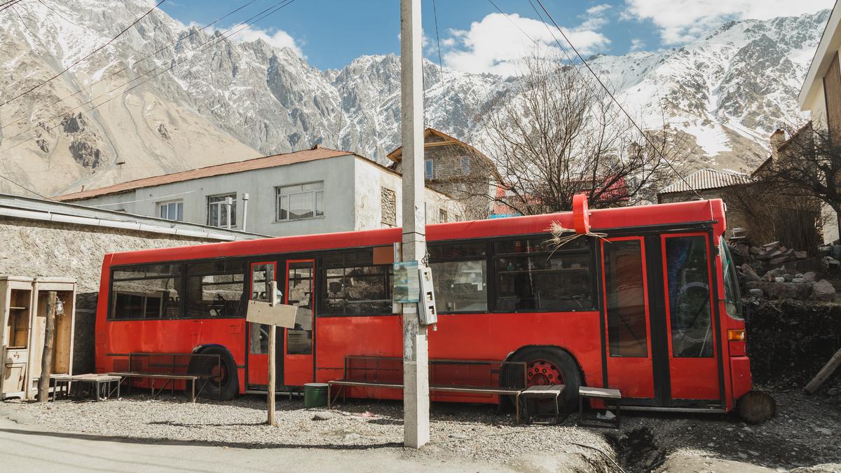 Красный автобус на остановке в Казбеги