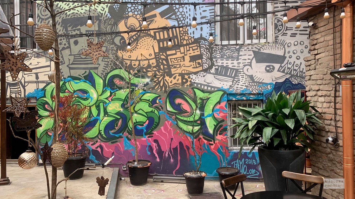 Граффити на стенах летней площадки бара Сулико