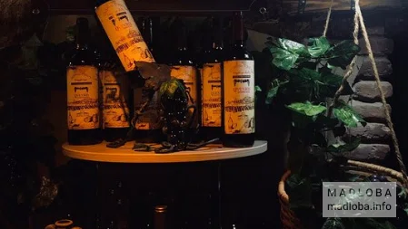 Стойка с бутылками вина в Taverna Dzveleburi Rachuli