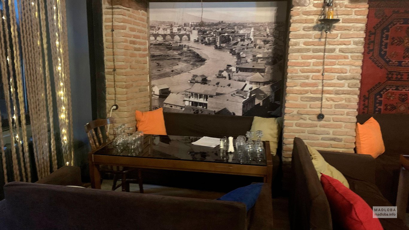 Столик на фоне черно-белой картины в Cafe Top shelf lounge