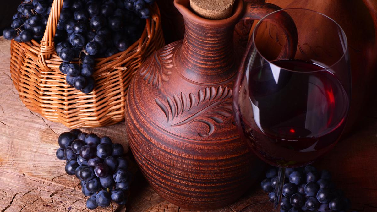Вино в кувшине и бокалы с виноградом