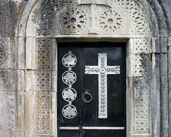 Черная дверь с крестом церкови Святого Георгия на скале Даба