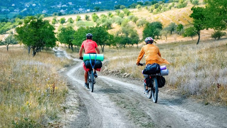 Велотуристы едут по сельской дороге