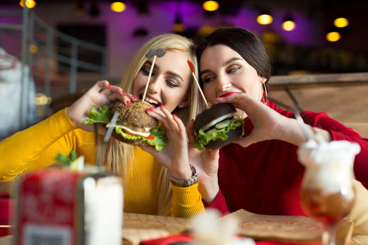 Две девушки едят бургеры