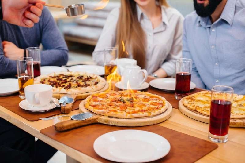 Young people at the table eating pizza