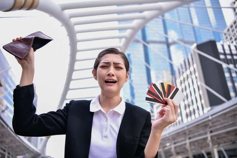 upset woman with empty wallet and credit cards