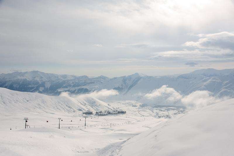 A view from the cable car of small houses and mountains in Gudauri