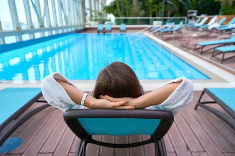 woman-lying-on-a-lounger-at-poolside.max-800x600