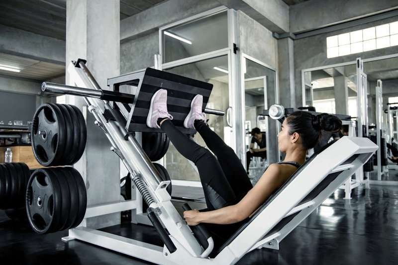 woman-playing-weights-with-legs-machine-in-m.max-800x600