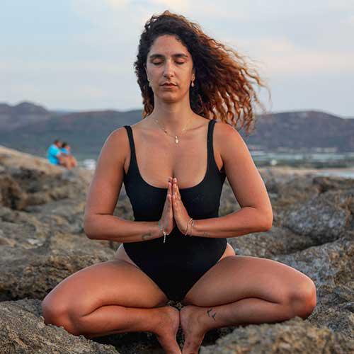 Женщина медитирует на пляже