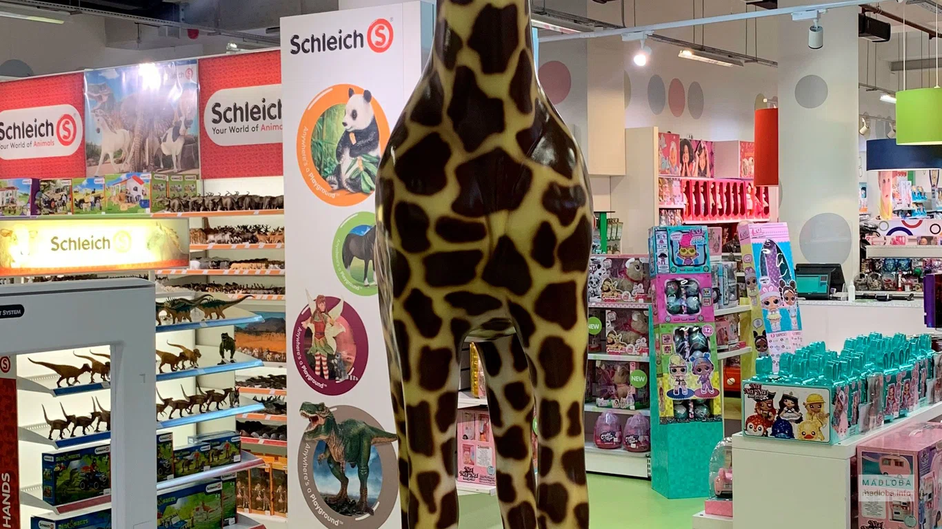 Жираф в магазине игрушек