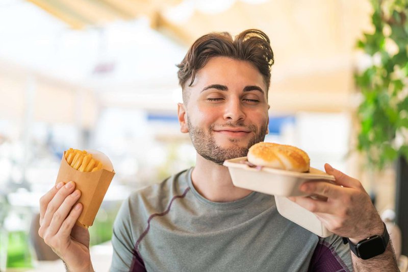 A young man is looking forward to a delicious burger lunch