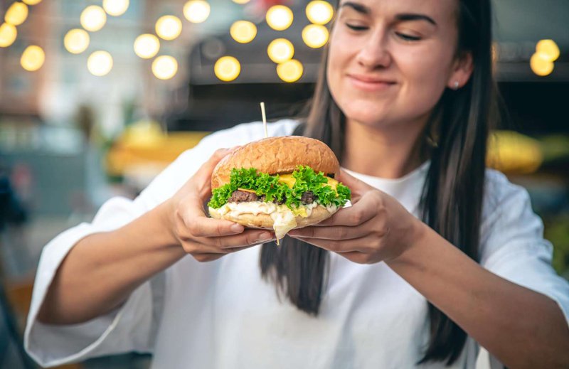 The girl is holding a non-standard burger