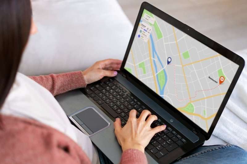 A woman with a laptop with Google Maps open